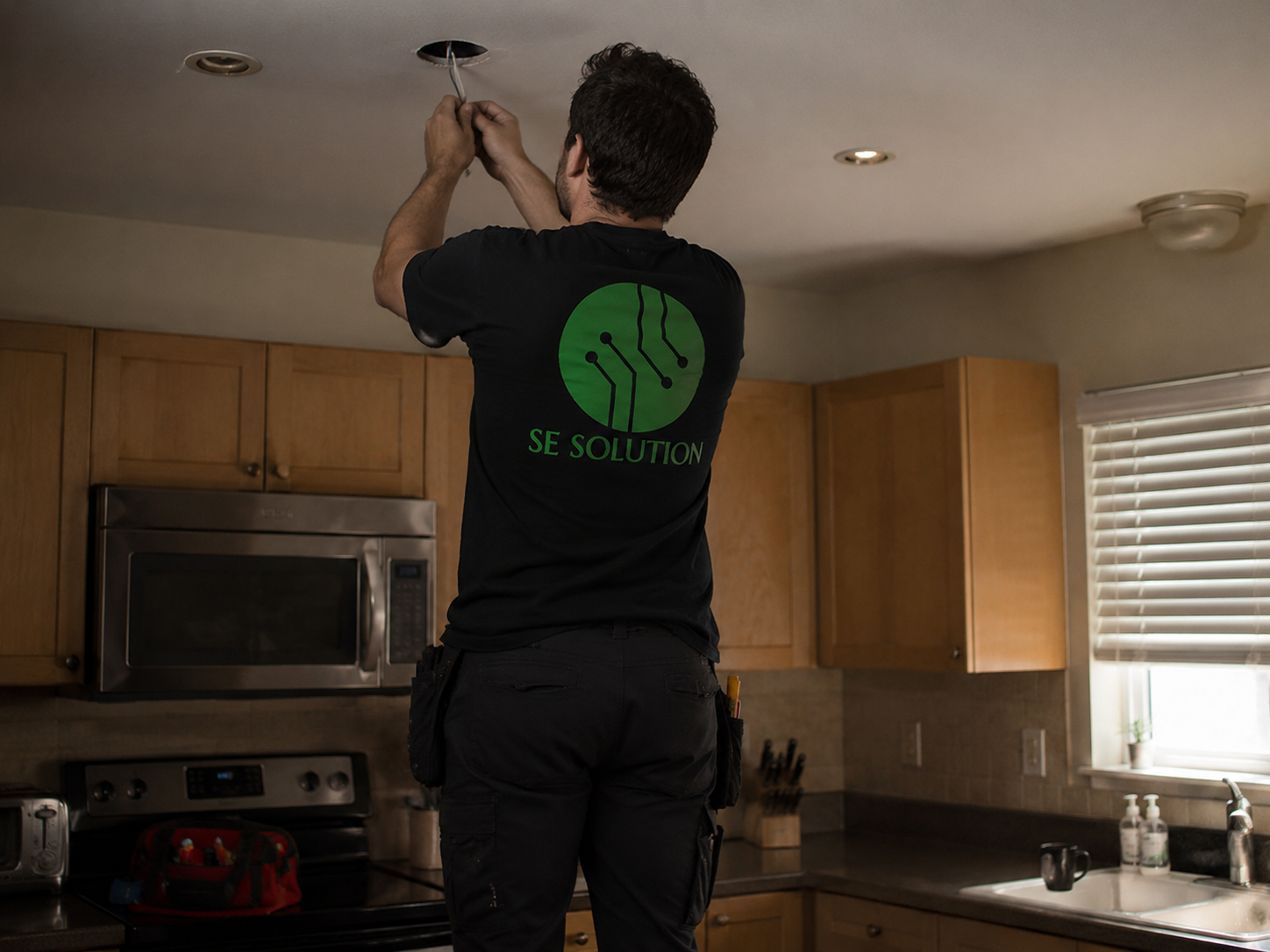 Electrician installing recessed kitchen lighting, Metro Detroit, MI